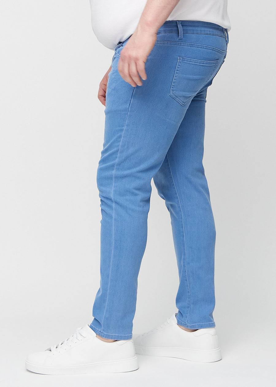 Blaue Jeans im Slim Fit, von der Seite an einem Plus-Size-Model gesehen.
