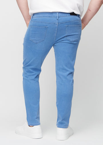 Blaue Jeans im Slim Fit, von hinten an einem Plus-Size-Model gesehen, um die gesamte Jeans zu zeigen.