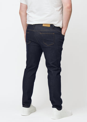 Tief dunkelblaue Denim jeans für Herren in der Farbe Midnights von hinten an einem Plus-Size-Model gesehen.