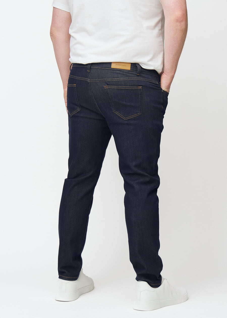 Tief dunkelblaue Denim jeans für Herren in der Farbe Midnights von hinten an einem Plus-Size-Model gesehen.