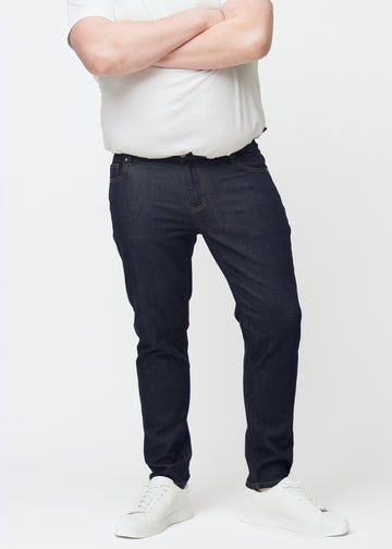 Tief dunkelblaue Denim jeans für Herren in der Farbe Midnights mit slim Passform, von vorne an einem Plus-Size-Model gesehen.