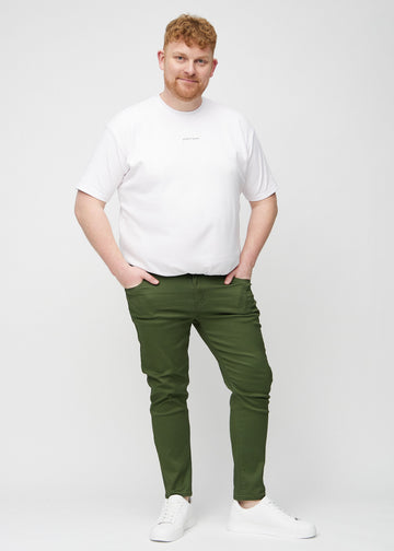 Ganzkörperaufnahme eines Plus-Size-Models in dunkelgrüne Jeans im Slim Fit.