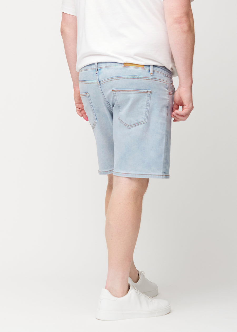 Hellblaue Denim-Shorts für Herren in der Farbe Waves von hinten an einem Plus-Size-Model gesehen, sodass die Länge bis knapp über das Knie zu sehen ist.