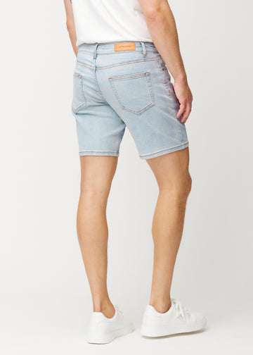 Hellblaue Denim-Shorts für Herren in der Farbe Waves von hinten gesehen, sodass die Länge bis knapp über das Knie und die Passform zu sehen sind.