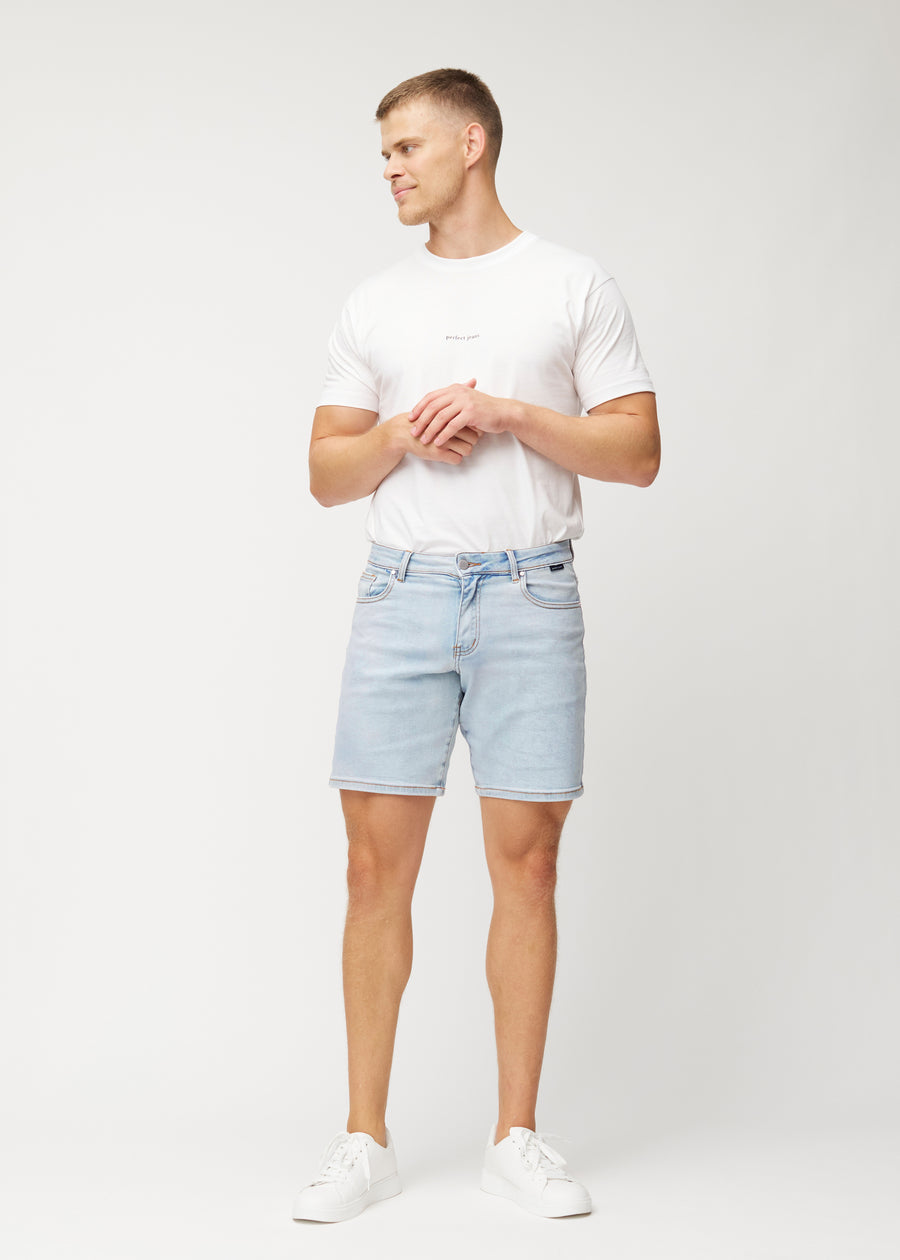 Ganzkörperbild eines Models in hellblauen Denim-Shorts für Herren in der Farbe Waves mit regular Passform.