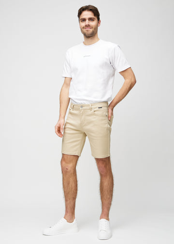 Ganzkörperbild eines Models in beige middle-slim Shorts.