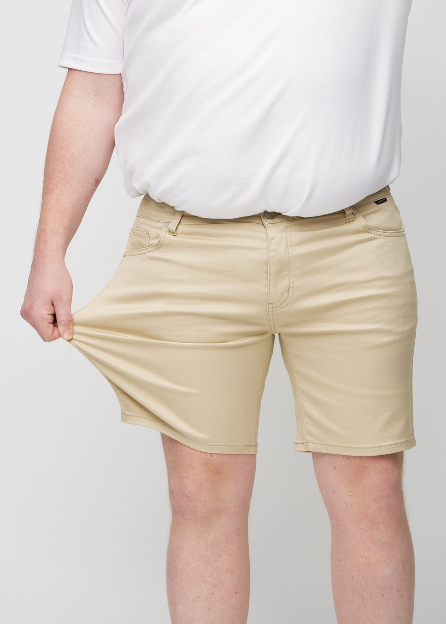 Das Plus-Size-Model zieht die Shorts am Oberschenkel, um den Stretch zu zeigen.
