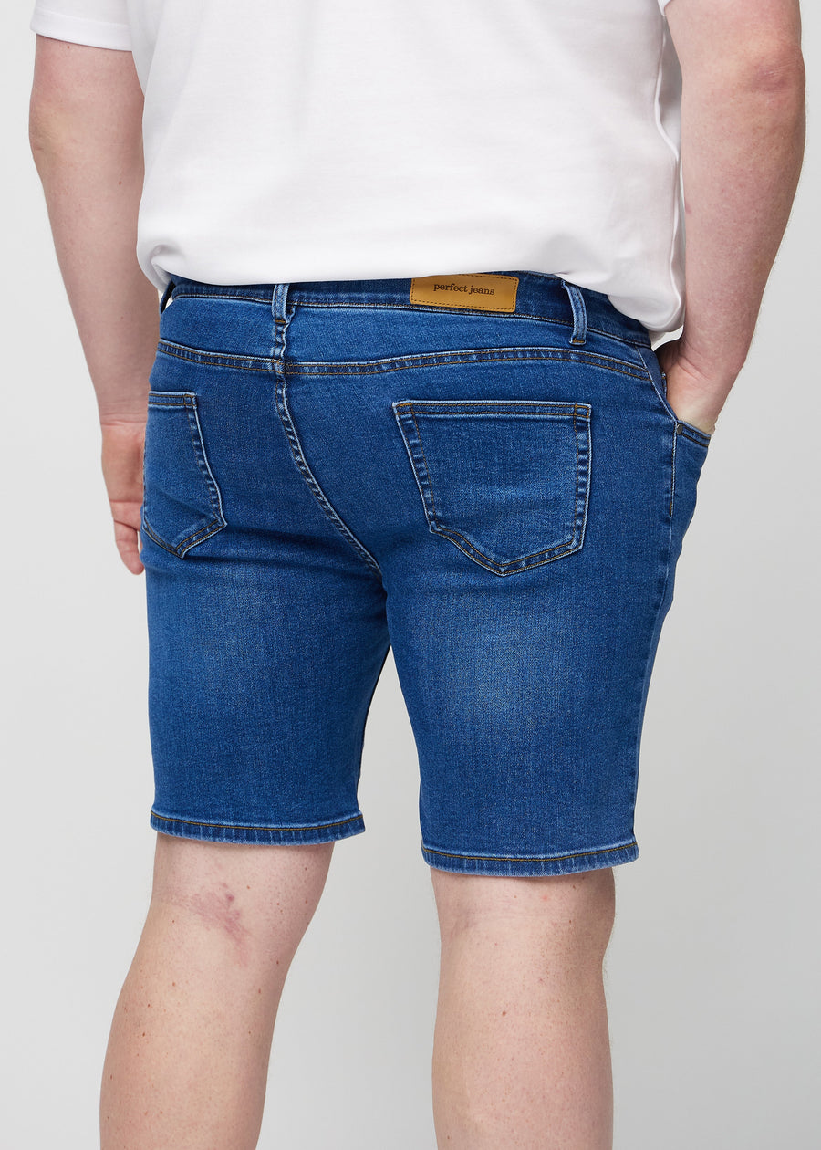 Dunkle Denim-Middle-slim-Shorts von hinten aus der Nähe an einem Plus-Size-Model gesehen, um Details zu zeigen.