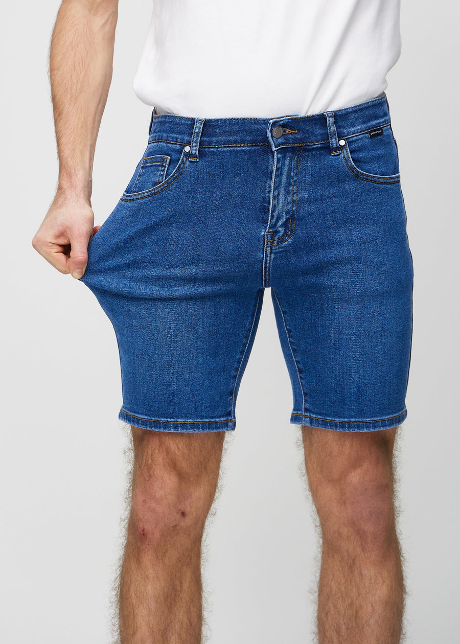 Das Model dehnt die Shorts am Oberschenkel, um den Stretch zu zeigen.