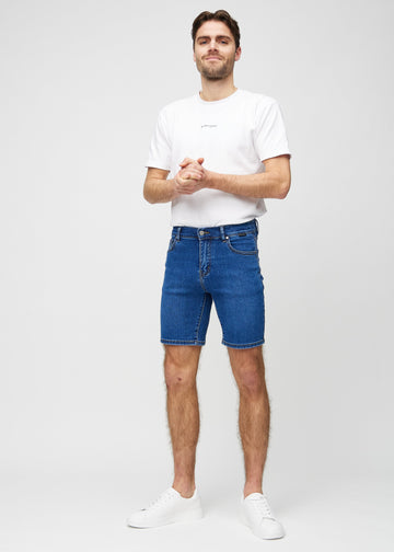 Ganzkörperbild eines Models in dunklen Denim-Middle-slim-Shorts.
