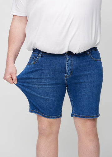 Das Plus-Size-Model dehnt die Shorts am Oberschenkel, um den Stretch zu zeigen.