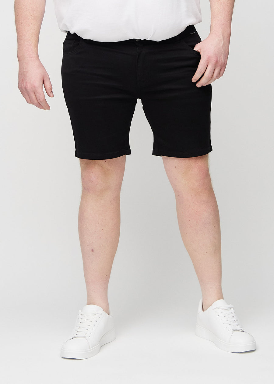 Schwarze middle-slim Shorts, die gerade am Oberschenkel sitzen und knapp über dem Knie enden, an einem Plus-Size-Model, von vorne gesehen.