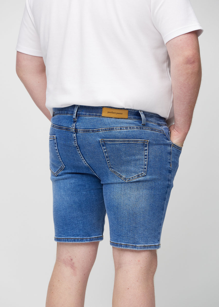 Denim middle-slim Shorts von hinten aus der Nähe an einem Plus-Size-Model gesehen, um Details zu zeigen.