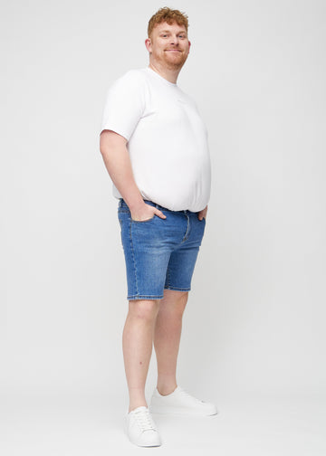 Ganzkörperbild eines Plus-Size-Models in Denim middle-slim Shorts.