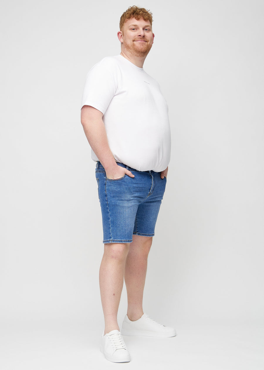 Ganzkörperbild eines Plus-Size-Models in Denim middle-slim Shorts.