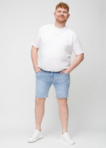 Ganzkörperbild eines Plus-Size-Models in hellblauen Denim middle-slim Shorts.
