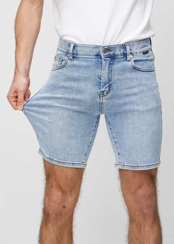 Das Model zieht die Shorts am Oberschenkel auseinander, um den Stretch zu zeigen.