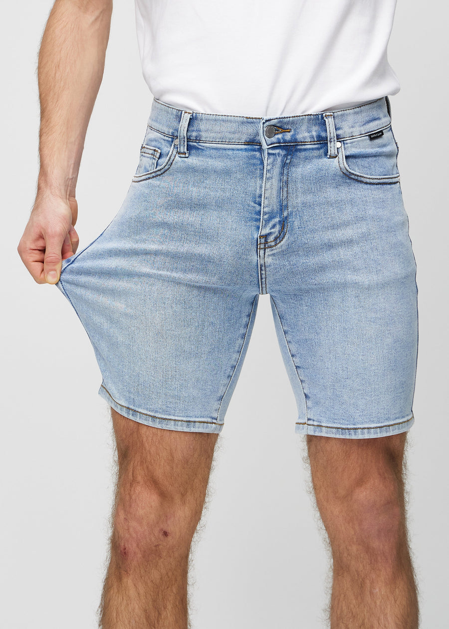 Das Model zieht die Shorts am Oberschenkel auseinander, um den Stretch zu zeigen.