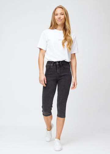 Fuldt billede af model iført mørkegrå denim slim capris.
