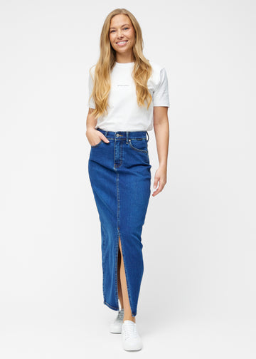 Model viser lang, mørkeblå denimnederdel i farven Oceans med regulær pasform i bevægelse og demonstrerer slids og materiale.